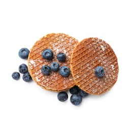Photo of Tasty Dutch waffles (stroopwafels) and blueberries isolated on white, top view