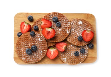 Photo of Tasty Dutch waffles (stroopwafels) and berries isolated on white, top view