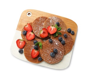Photo of Tasty Dutch waffles (stroopwafels) and berries isolated on white, top view