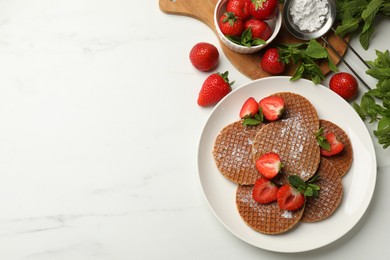 Photo of Tasty Dutch waffles (stroopwafels), mint and strawberries on white marble table, flat lay. Space for text