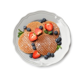 Photo of Tasty Dutch waffles (stroopwafels), mint and berries isolated on white, top view