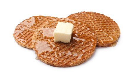 Photo of Tasty Dutch waffles (stroopwafels) with honey and butter cube isolated on white