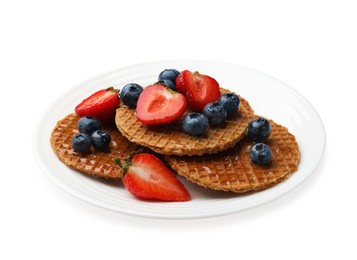 Photo of Tasty Dutch waffles (stroopwafels) with honey, strawberries and blueberries isolated on white