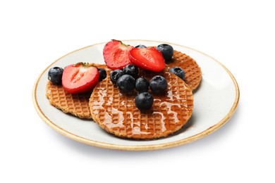Photo of Tasty Dutch waffles (stroopwafels) with honey, strawberries and blueberries isolated on white
