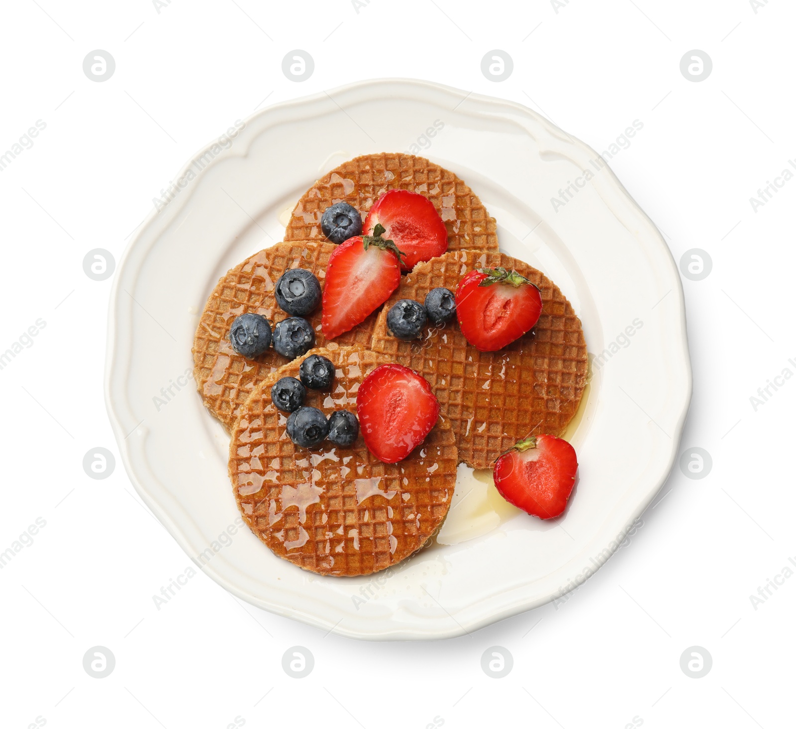 Tasty Dutch waffles (stroopwafels) with honey, strawberries and blueberries isolated on white, top view Photo of Tasty Dutch waffles (stroopwafels) with honey, strawberries and blueberries isolated on white, top view