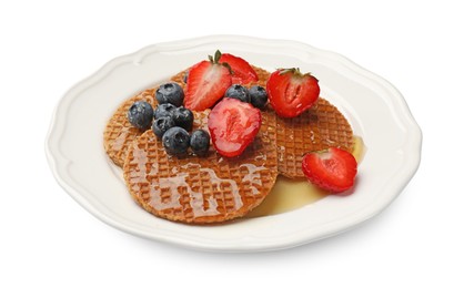 Photo of Tasty Dutch waffles (stroopwafels) with honey, strawberries and blueberries isolated on white