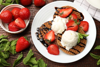 Photo of Tasty Dutch waffles (stroopwafels) with strawberries, ice cream and chocolate sauce on wooden table, flat lay