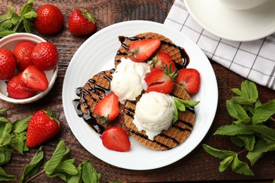 Photo of Tasty Dutch waffles (stroopwafels) with strawberries, ice cream and chocolate sauce on wooden table, flat lay