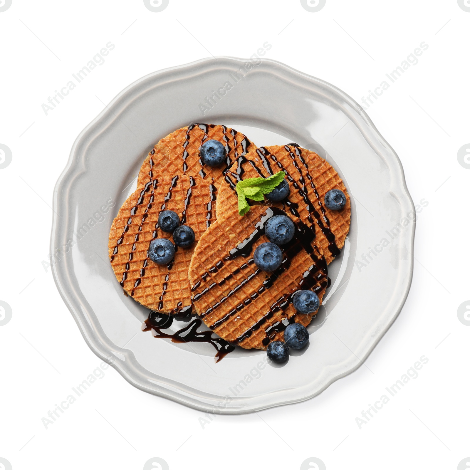 Tasty Dutch waffles (stroopwafels) with blueberries and chocolate sauce isolated on white, top view Photo of Tasty Dutch waffles (stroopwafels) with blueberries and chocolate sauce isolated on white, top view
