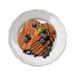 Photo of Tasty Dutch waffles (stroopwafels) with blueberries and chocolate sauce isolated on white, top view