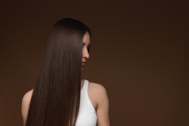 Photo of Teenage girl with healthy long hair on brown background. Space for text