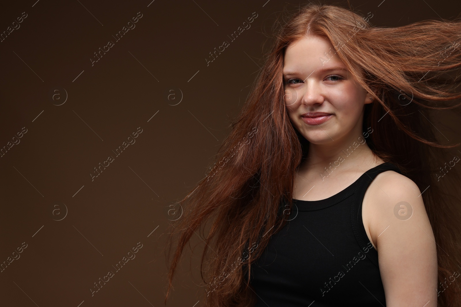 Portrait of beautiful teenage girl with healthy wavy hair on brown background. Space for text Photo of Portrait of beautiful teenage girl with healthy wavy hair on brown background. Space for text