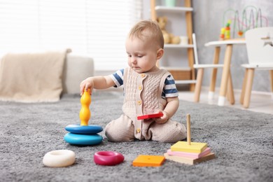 Photo of Cute little baby playing with toys in room
