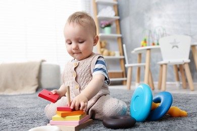 Photo of Cute little baby playing with toys in room