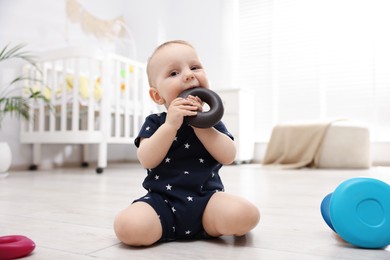 Photo of Cute little baby playing with toy pyramid in room