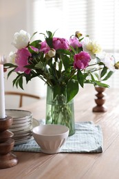 Photo of Dining table with beautiful flowers and dishware indoors. Interior design