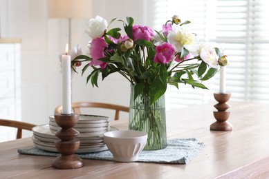 Photo of Dining table with beautiful flowers and dishware in room. Interior design