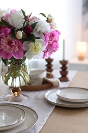 Photo of Beautiful table setting with bouquet of peonies indoors, closeup