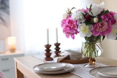 Photo of Beautiful table setting with bouquet of peonies in dining room, closeup. Space for text
