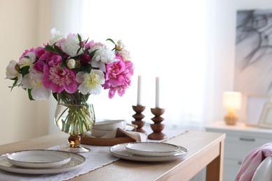 Photo of Beautiful table setting with bouquet of peonies in dining room, closeup. Space for text