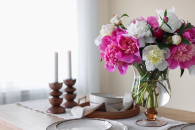 Photo of Beautiful table setting with bouquet of peonies indoors, closeup. Space for text