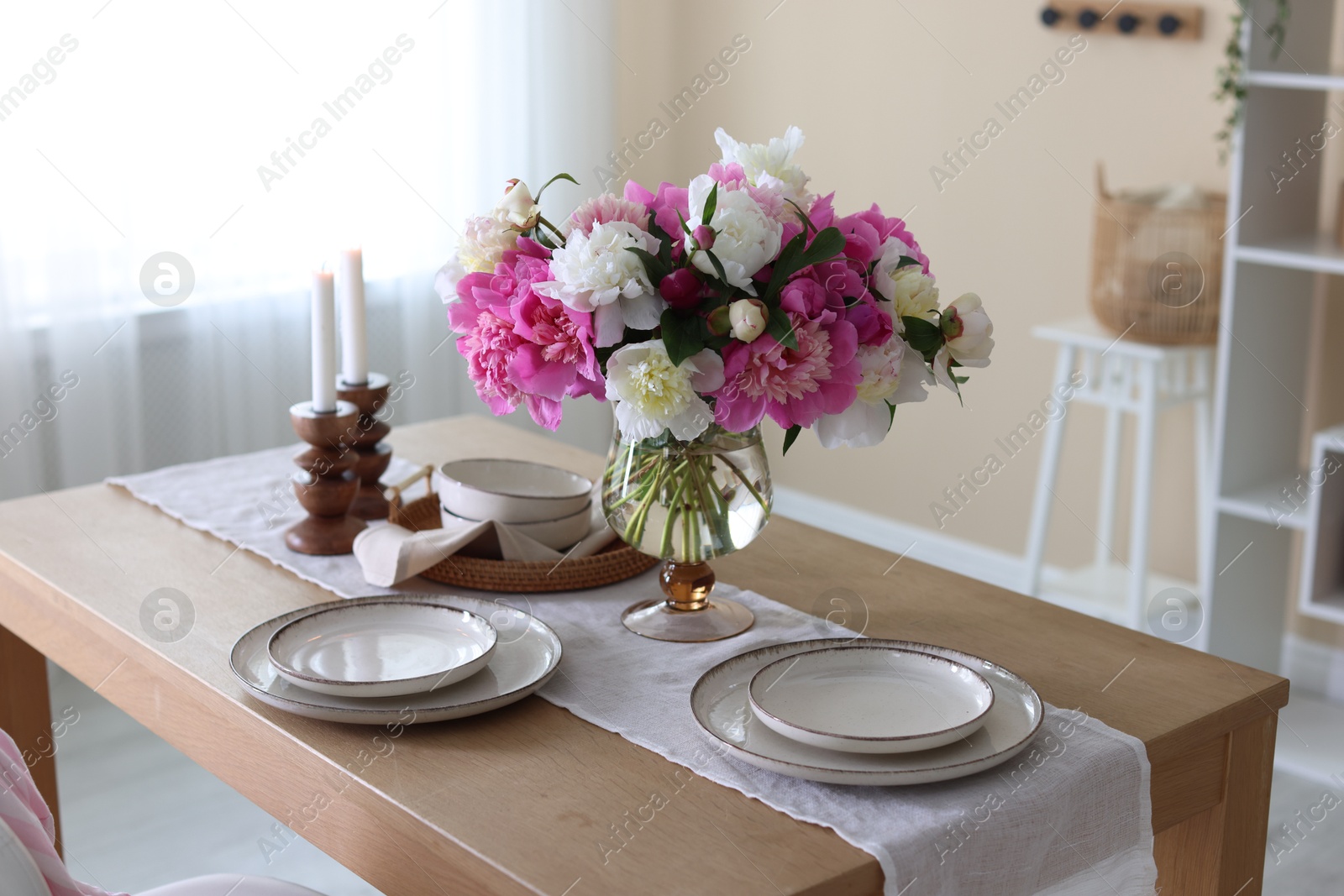 Beautiful table setting with bouquet of peonies in dining room Photo of Beautiful table setting with bouquet of peonies in dining room