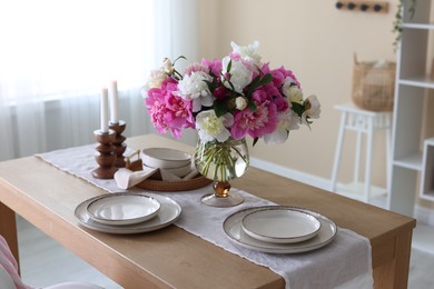 Photo of Beautiful table setting with bouquet of peonies in dining room