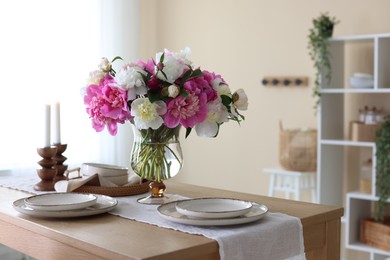 Photo of Beautiful table setting with bouquet of peonies in dining room