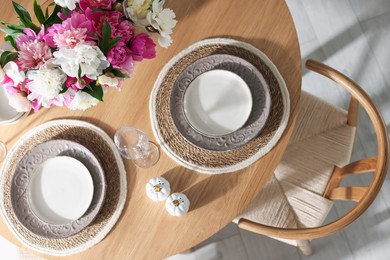 Photo of Beautiful table setting with bouquet of peonies indoors, top view