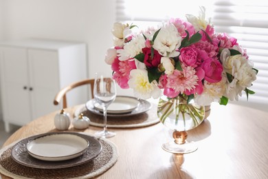 Photo of Beautiful table setting with bouquet of peonies in dining room, closeup
