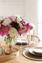 Photo of Beautiful table setting with bouquet of peonies indoors, closeup