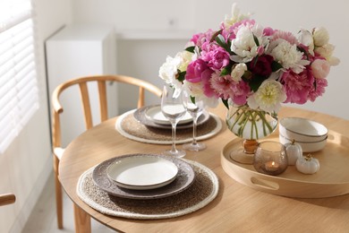 Photo of Beautiful table setting with bouquet of peonies in dining room, closeup