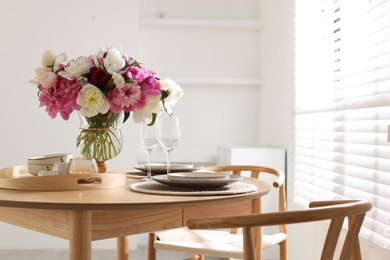 Photo of Beautiful table setting with bouquet of peonies in dining room. Space for text
