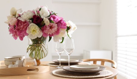 Photo of Beautiful table setting with bouquet of peonies in dining room, closeup. Space for text