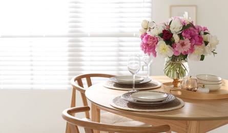 Photo of Beautiful table setting with bouquet of peonies in dining room. Space for text