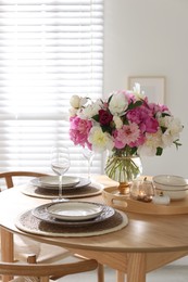 Photo of Beautiful table setting with bouquet of peonies in dining room