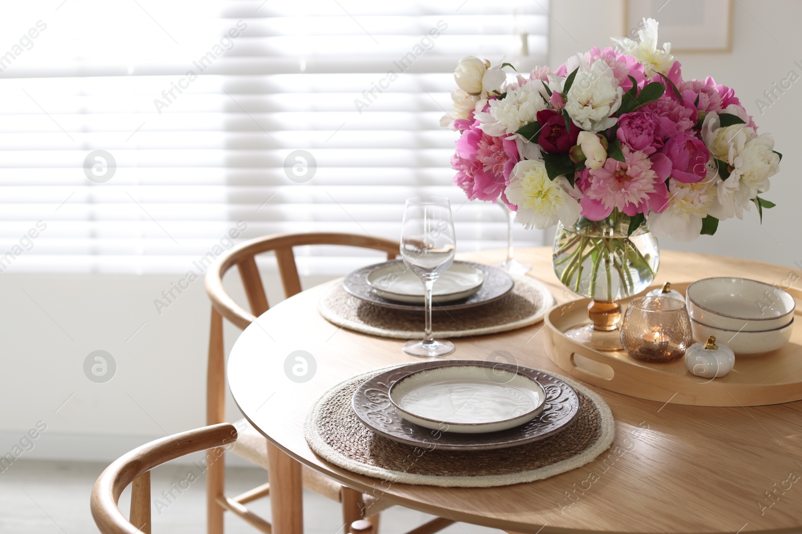 Beautiful table setting with bouquet of peonies in dining room. Space for text Photo of Beautiful table setting with bouquet of peonies in dining room. Space for text
