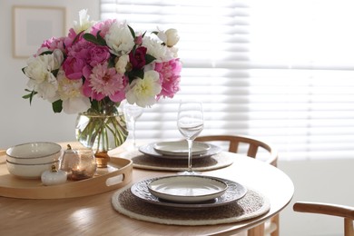 Photo of Beautiful table setting with bouquet of peonies in dining room. Space for text