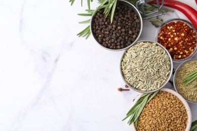 Photo of Different aromatic spices on white marble table, flat lay. Space for text