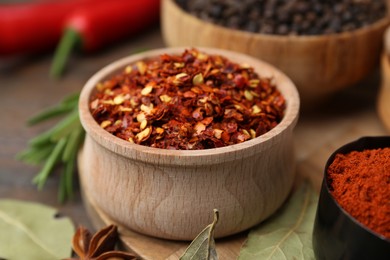 Photo of Different aromatic spices on wooden table, closeup