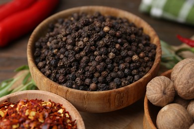 Photo of Different aromatic spices on wooden table, closeup