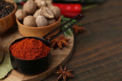 Photo of Different aromatic spices on wooden table, closeup. Space for text