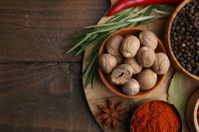 Photo of Different aromatic spices on wooden table, flat lay. Space for text