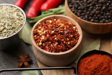 Photo of Different aromatic spices on wooden table, closeup