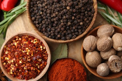 Photo of Different aromatic spices on wooden table, closeup
