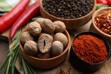Photo of Different aromatic spices on wooden table, closeup