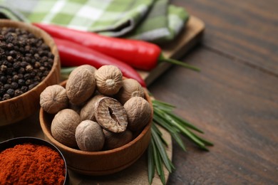 Photo of Different aromatic spices on wooden table, closeup. Space for text
