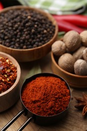 Photo of Different aromatic spices on wooden table, closeup