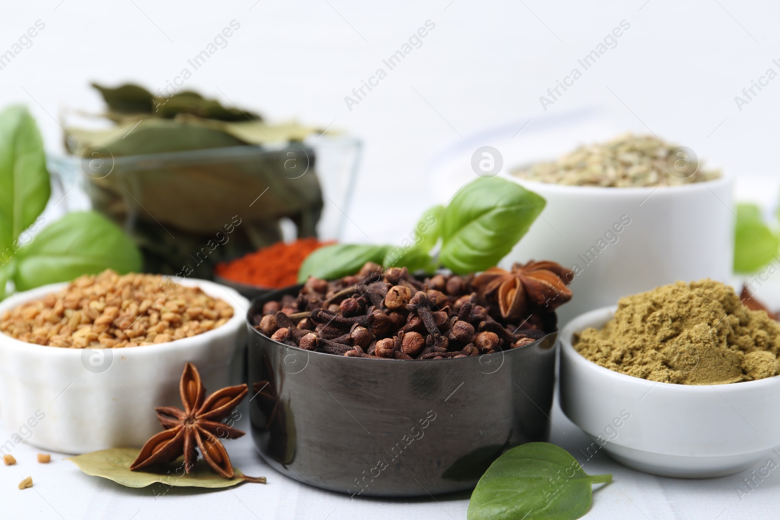 Different aromatic spices on white table, closeup Photo of Different aromatic spices on white table, closeup
