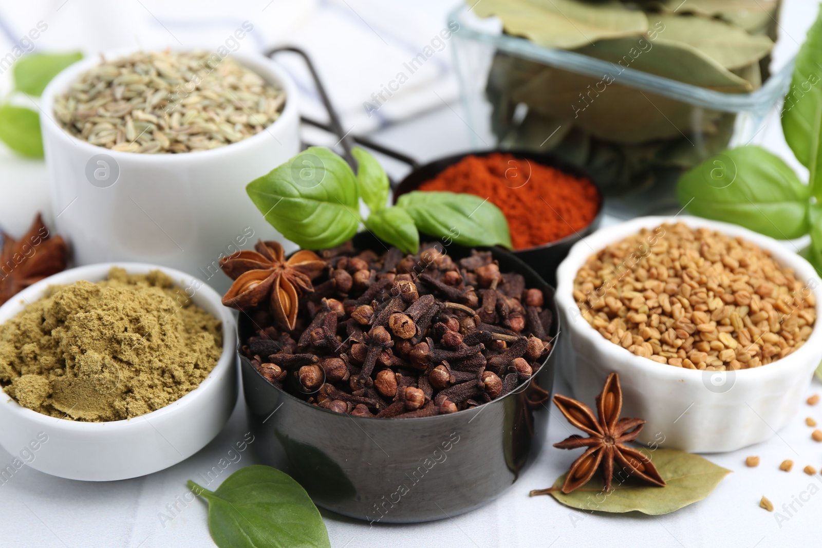 Different aromatic spices on white table, closeup Photo of Different aromatic spices on white table, closeup